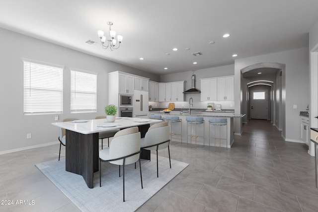 kitchen featuring a breakfast bar, a kitchen island with sink, and white cabinetry