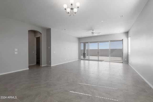 tiled empty room featuring ceiling fan with notable chandelier