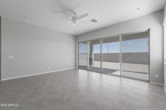 tiled empty room featuring ceiling fan