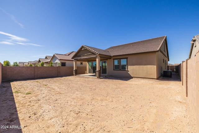 rear view of property with central AC unit and a patio