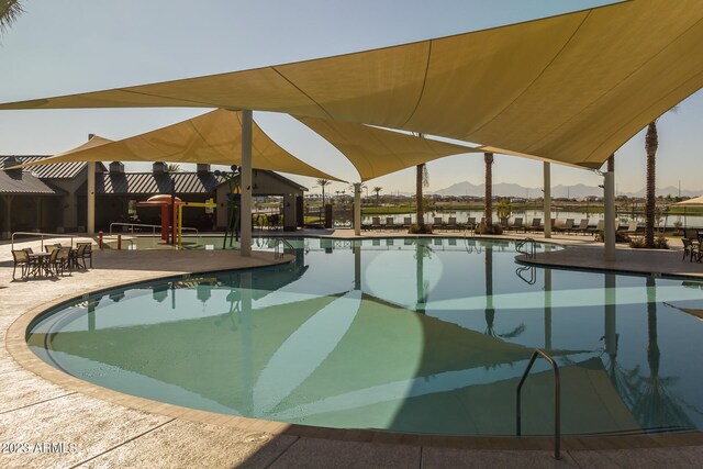 view of swimming pool featuring a mountain view and a patio