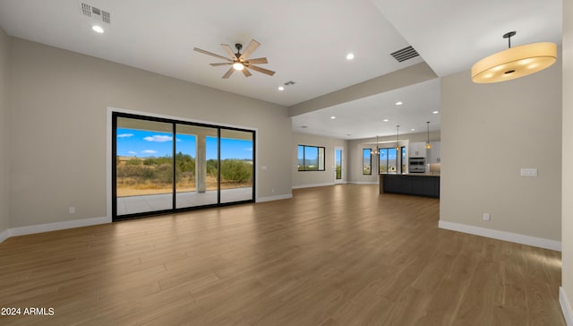 unfurnished living room featuring ceiling fan and hardwood / wood-style floors