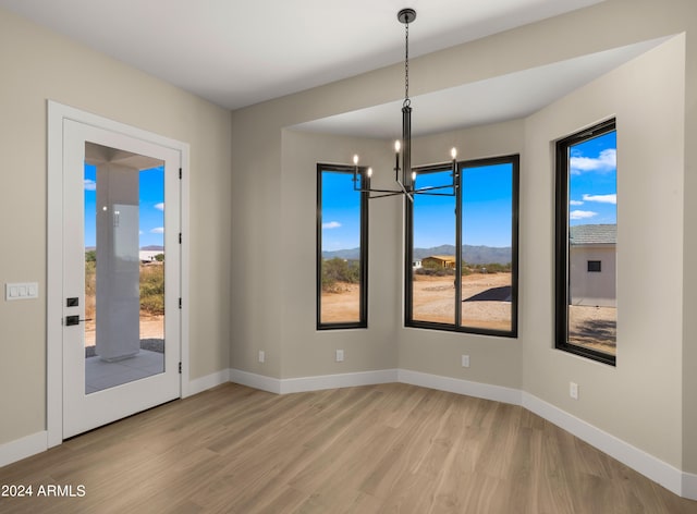 29811 N 154th St, Scottsdale, AZ 85262 - unfurnished room with baseboards, plenty of natural light, light wood-type flooring, and an inviting chandelier