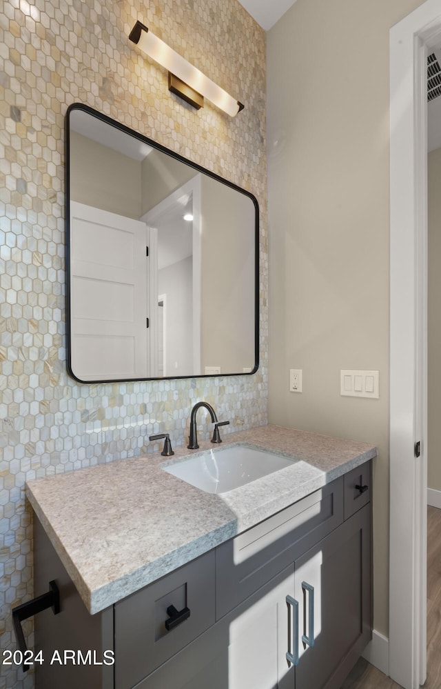 bathroom featuring backsplash, hardwood / wood-style floors, and vanity