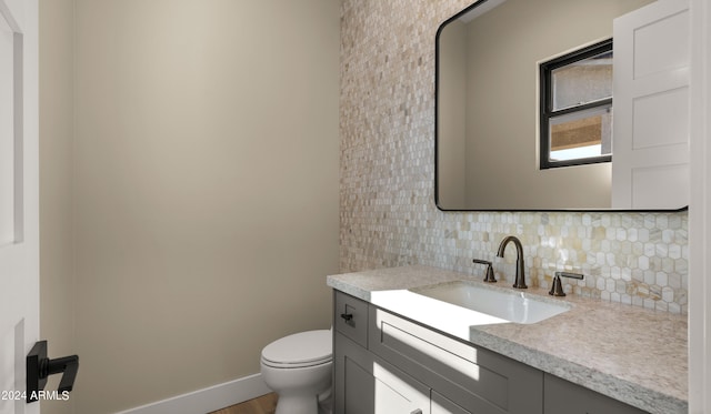 bathroom featuring tasteful backsplash, hardwood / wood-style flooring, vanity, and toilet