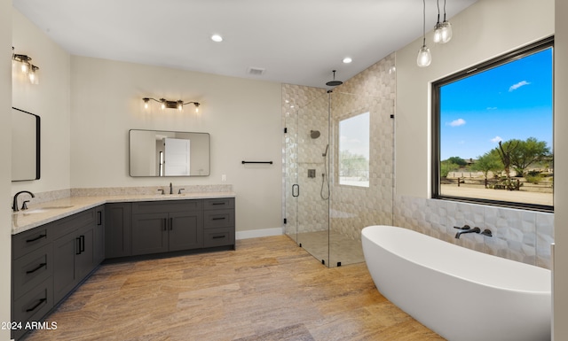 bathroom with vanity, shower with separate bathtub, and tile walls