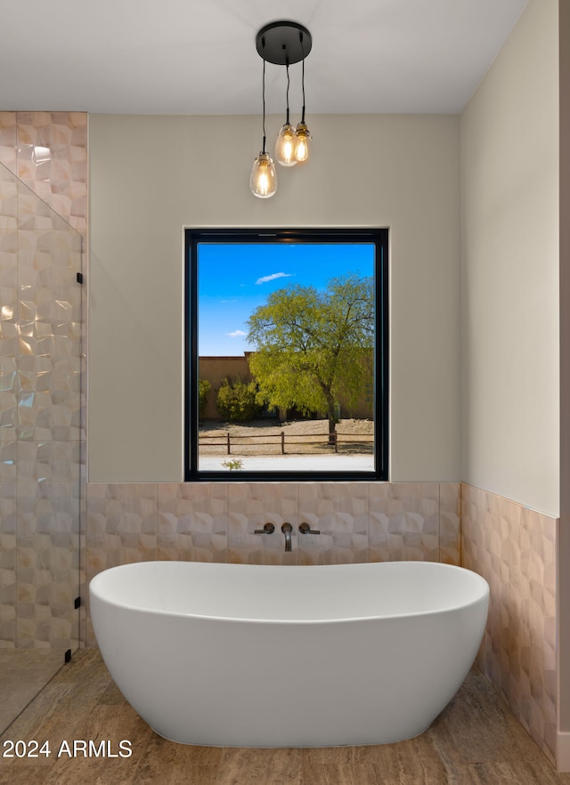 bathroom featuring tile walls and independent shower and bath