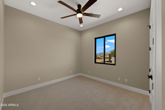 unfurnished room featuring light colored carpet and ceiling fan