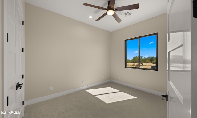 empty room featuring ceiling fan and light colored carpet