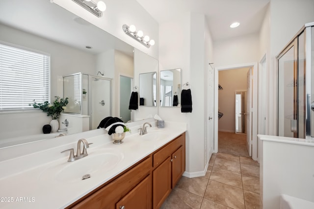 bathroom featuring double vanity, a sink, a shower stall, and tile patterned floors