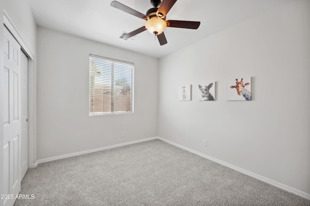 unfurnished bedroom featuring baseboards, visible vents, a ceiling fan, carpet floors, and a closet