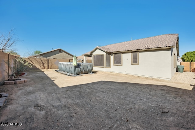 back of property featuring a patio, a fenced backyard, a tile roof, a pool, and stucco siding