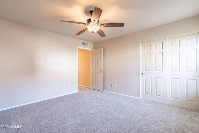 unfurnished bedroom featuring baseboards, visible vents, a ceiling fan, carpet flooring, and a closet