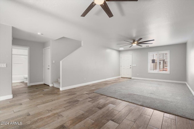 unfurnished living room featuring a textured ceiling, light hardwood / wood-style flooring, and ceiling fan