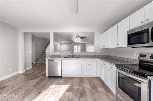 kitchen with light hardwood / wood-style floors, sink, white cabinetry, and stainless steel appliances