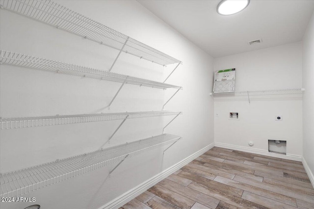 clothes washing area with washer hookup, electric dryer hookup, gas dryer hookup, and light hardwood / wood-style flooring