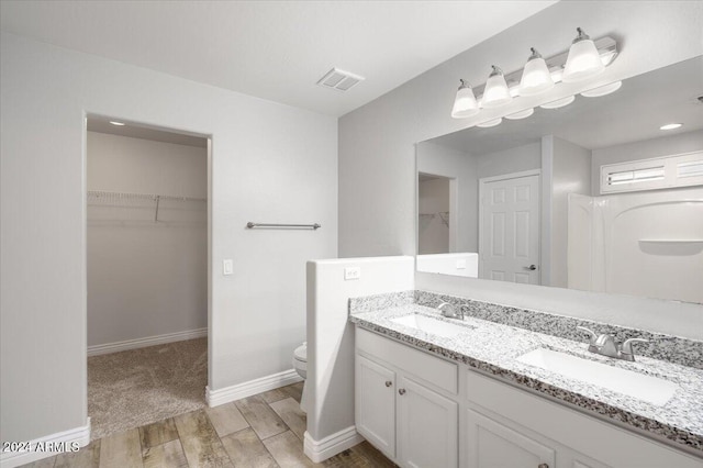 bathroom with hardwood / wood-style flooring, vanity, and toilet