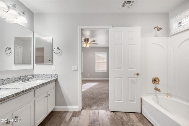 bathroom featuring hardwood / wood-style flooring, ceiling fan,  shower combination, and vanity