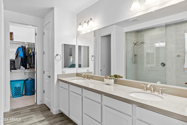 bathroom with vanity, wood-type flooring, and tiled shower