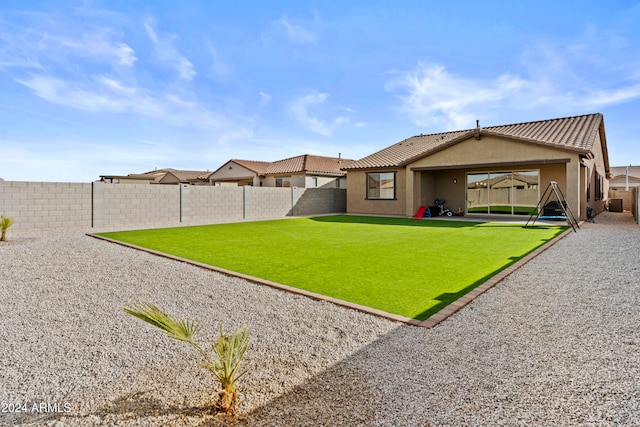 rear view of property with a lawn