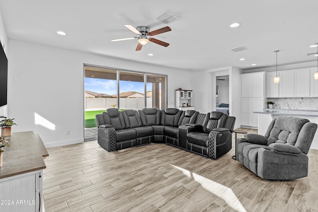 living room with ceiling fan and light hardwood / wood-style flooring