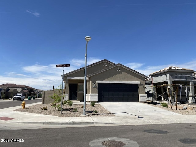 view of front of home featuring driveway, an attached garage, and stucco siding