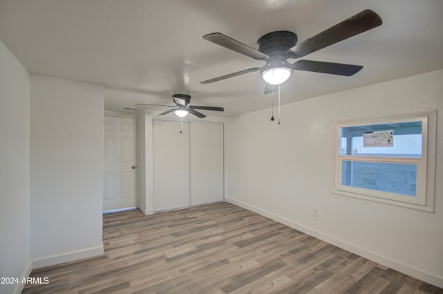 unfurnished bedroom with a closet, ceiling fan, and light wood-type flooring