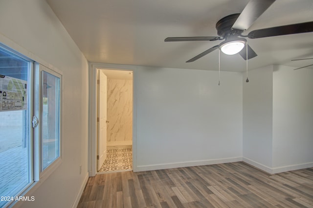 empty room with hardwood / wood-style floors and ceiling fan