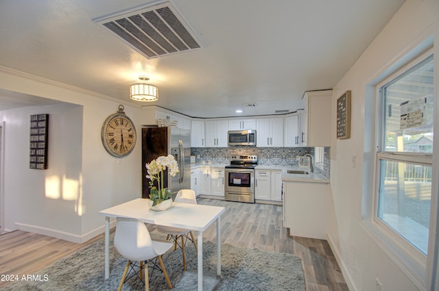 dining space with sink and light hardwood / wood-style flooring