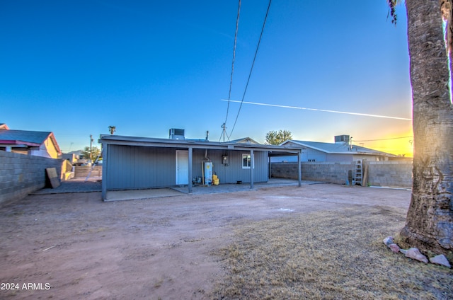 back house at dusk featuring central AC unit