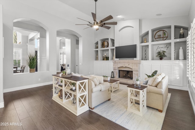 living room featuring ceiling fan, wood-type flooring, and built in features