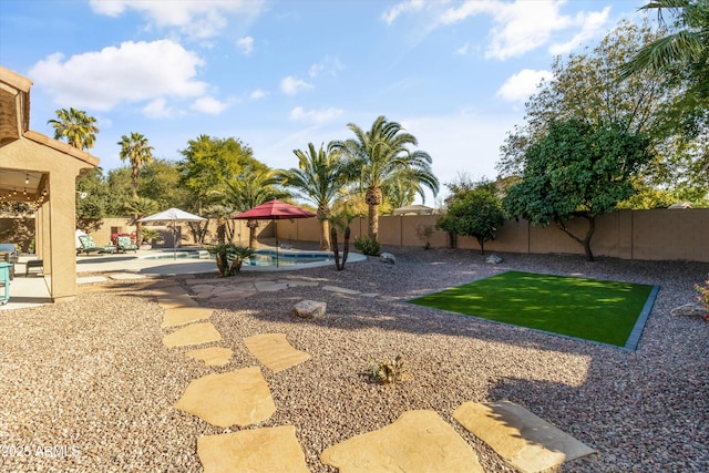 view of yard with a fenced in pool and a patio