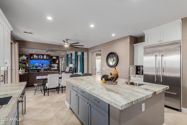 16178 W Granada Rd, Goodyear, AZ 85395 - kitchen featuring built in fridge, white cabinets, a ceiling fan, a kitchen island with sink, and open floor plan