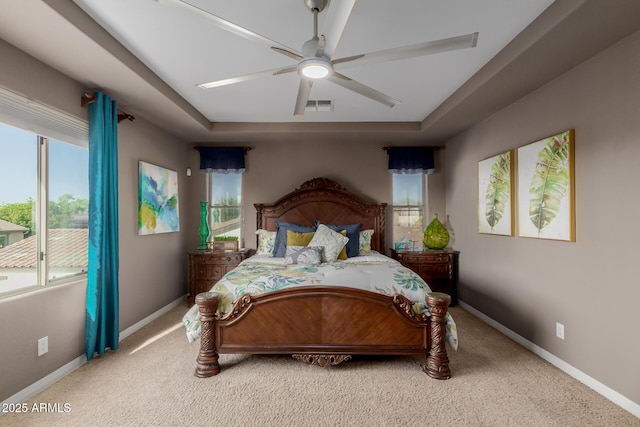 16178 W Granada Rd, Goodyear, AZ 85395 - bedroom featuring light colored carpet, a tray ceiling, and a ceiling fan