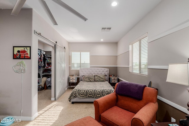 16178 W Granada Rd, Goodyear, AZ 85395 - bedroom with a barn door, a spacious closet, carpet flooring, recessed lighting, and a closet