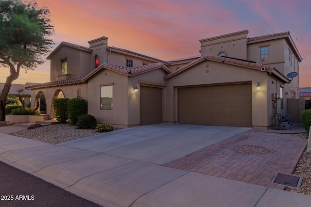 16178 W Granada Rd, Goodyear, AZ 85395 - mediterranean / spanish home with an attached garage, concrete driveway, a tiled roof, and stucco siding