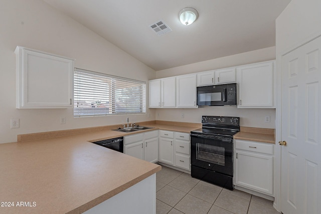 kitchen with vaulted ceiling, white cabinets, black appliances, sink, and light tile patterned floors