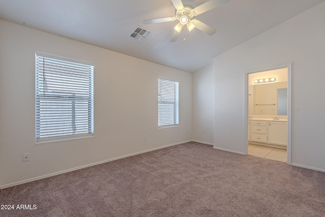 unfurnished bedroom featuring ensuite bathroom, ceiling fan, light carpet, and lofted ceiling