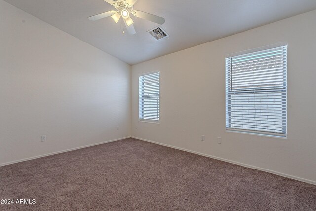 empty room with ceiling fan, carpet flooring, and vaulted ceiling