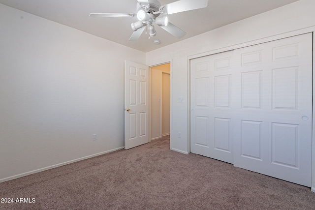 unfurnished bedroom with ceiling fan, light colored carpet, and a closet