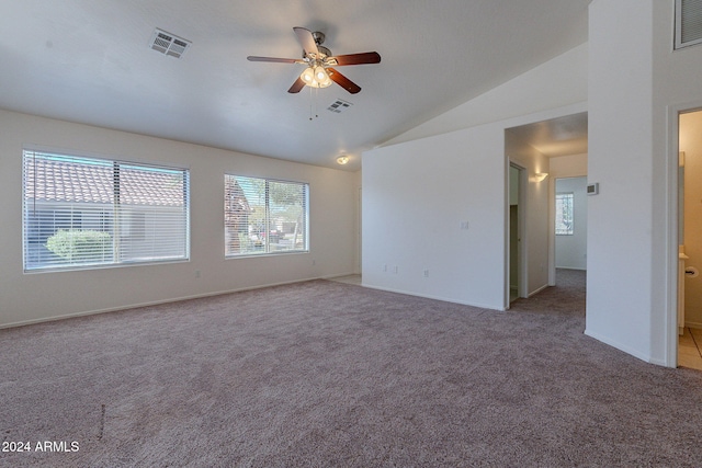 carpeted spare room featuring a wealth of natural light, ceiling fan, and vaulted ceiling