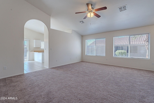 carpeted spare room with ceiling fan and vaulted ceiling