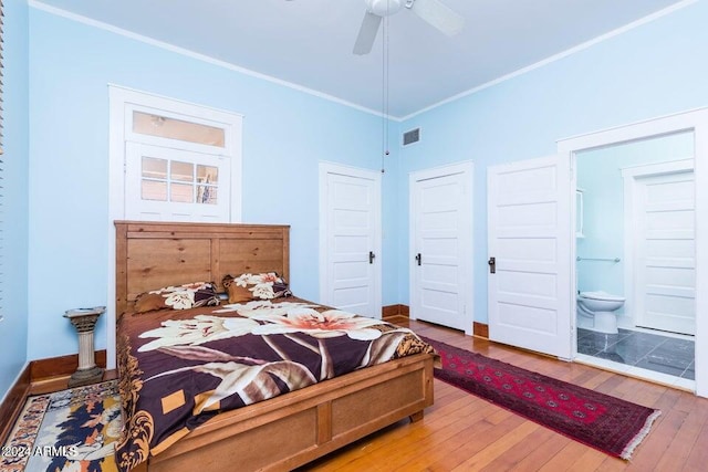 bedroom featuring ensuite bathroom, baseboards, ornamental molding, and hardwood / wood-style flooring