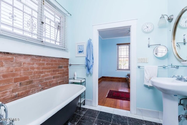 full bath with crown molding, baseboards, a freestanding tub, and tile patterned flooring