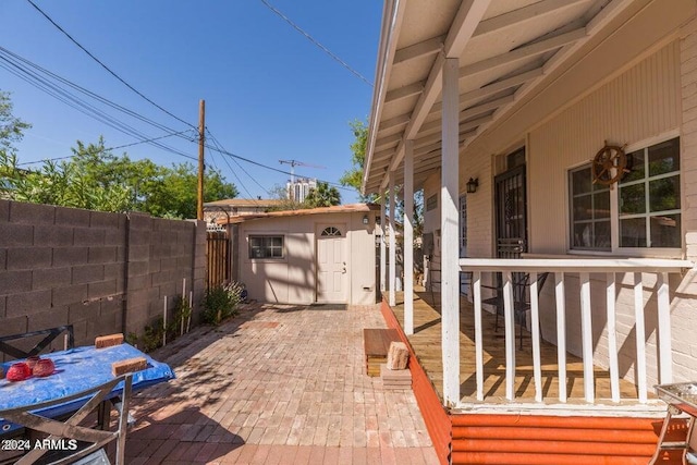 view of patio with an outbuilding, a fenced backyard, and a storage unit