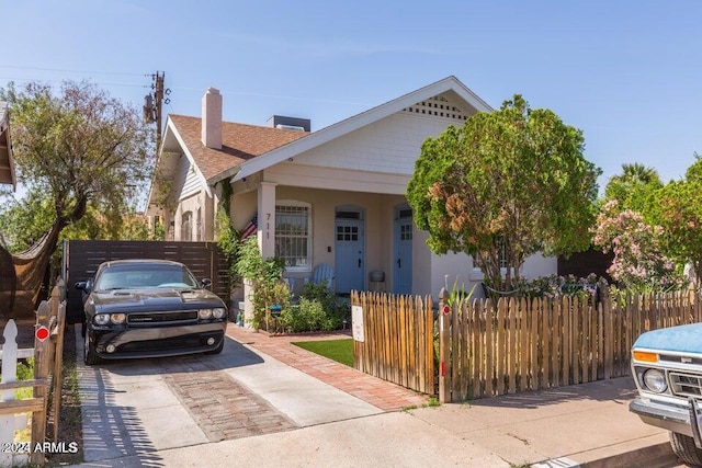 view of front of property with a chimney, a shingled roof, and a fenced front yard