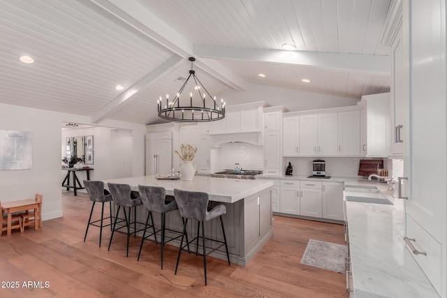 6196 E Calle Camelia, Scottsdale, AZ 85251 - kitchen with a chandelier, tasteful backsplash, white cabinets, a large island, and recessed lighting