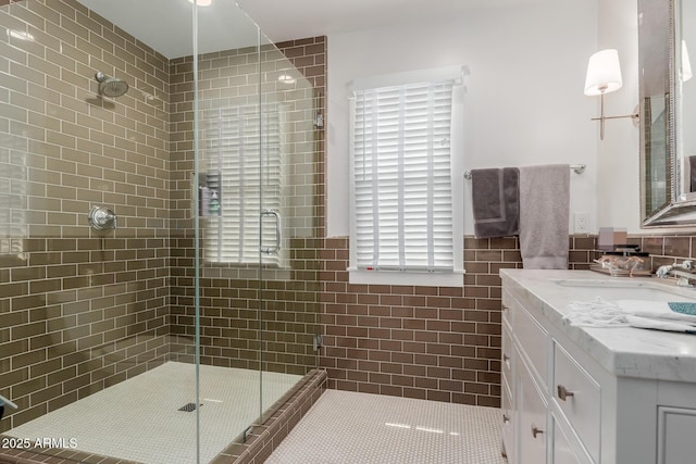 6196 E Calle Camelia, Scottsdale, AZ 85251 - bathroom with a shower stall, vanity, tile walls, tile patterned flooring, and wainscoting