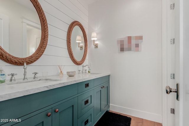 6196 E Calle Camelia, Scottsdale, AZ 85251 - bathroom featuring double vanity, baseboards, and wood finished floors