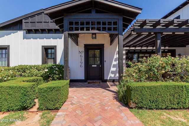 6196 E Calle Camelia, Scottsdale, AZ 85251 - view of exterior entry featuring board and batten siding and a pergola